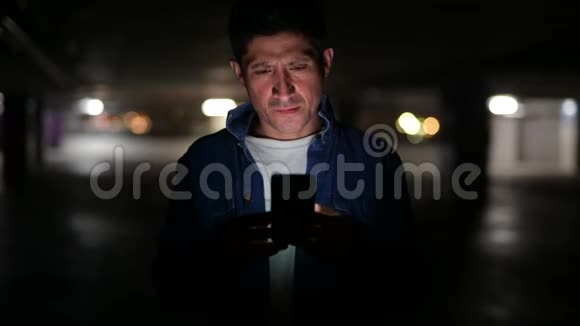 一个可疑的西班牙男人在黑暗的停车场用电话思考视频的预览图