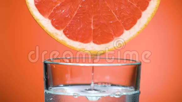 从葡萄柚或西西里红橙杯中流出的果汁滴视频的预览图
