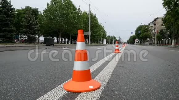 城市道路背景下带有白色条纹的交通标志橙色锥的特写图像视频的预览图
