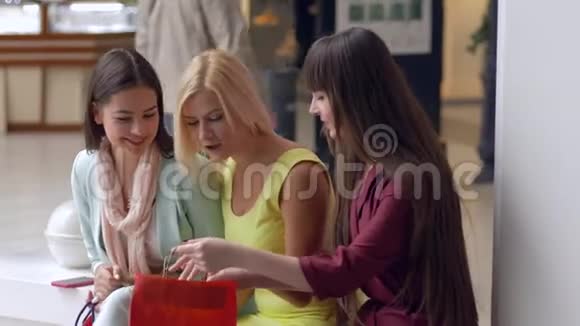 快乐女朋友在销售和折扣季节讨论从昂贵的精品店购买新产品视频的预览图