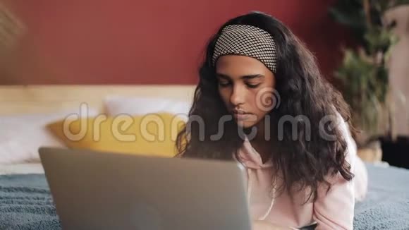 一个女人在她的电脑上收到信息后会非常生气和生气她躺在床上回家视频的预览图