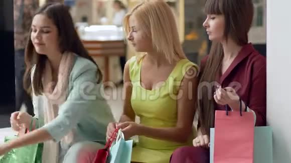购物的快乐女朋友们讨论在销售旺季从昂贵的精品店购买的新商品视频的预览图