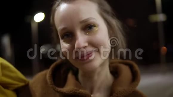 年轻活泼的女人穿着黄色夹克在外面跳舞别紧张微笑手持录像视频的预览图