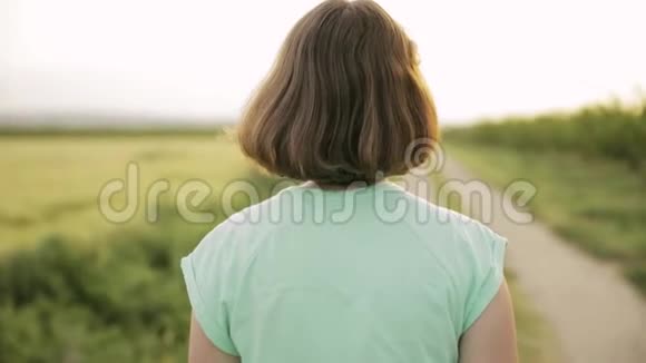 年轻的白种人妇女享受生活和在西班牙乡村道路上慢跑通过农村麦田景观视频的预览图