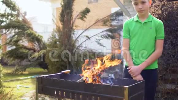 三个男孩在花园里的烧烤场生火视频的预览图