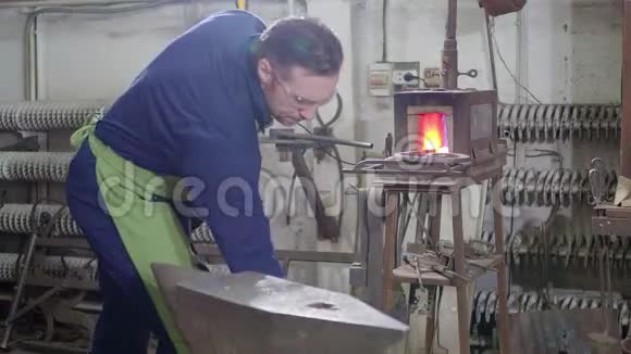 4K铁匠从炉子里拿出一滴铁水他用铁锤敲打一块铁水视频的预览图