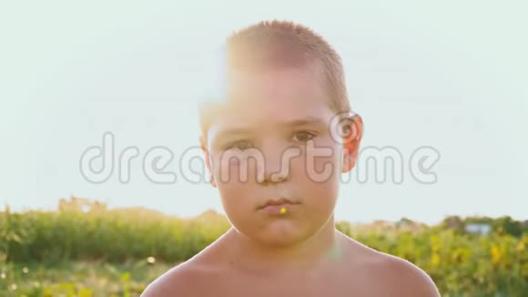 一个胖乎乎的男孩的肖像黑眼睛的背景是一片绿色的田野一个悲伤的孩子赤裸的躯干和一个视频的预览图