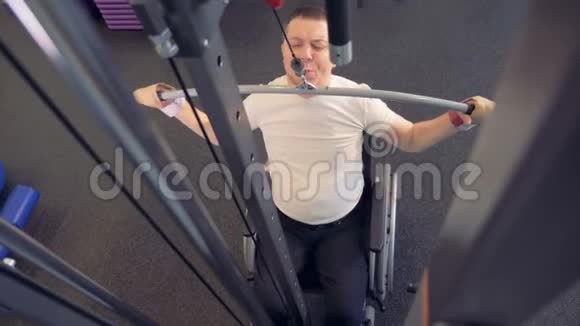 坐轮椅的运动员在健身房锻炼背部肌肉视频的预览图