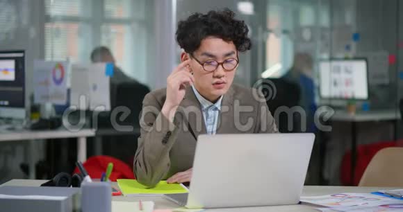 疲惫的亚洲年轻程序员戴眼镜视频的预览图