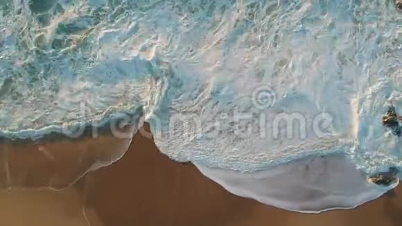 空中无人机拍摄的白色海浪在沙滩上破碎相机拉回视频的预览图