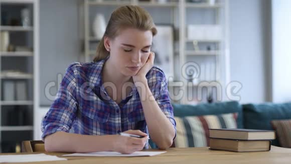 疲惫的年轻女子在纸上写字睡觉视频的预览图