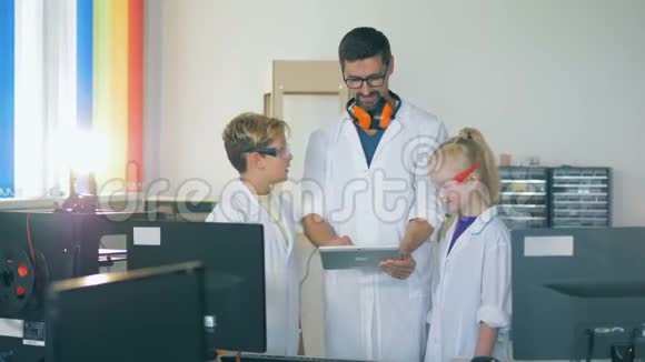 一位老师和孩子们在学校实验室里学习技术视频的预览图