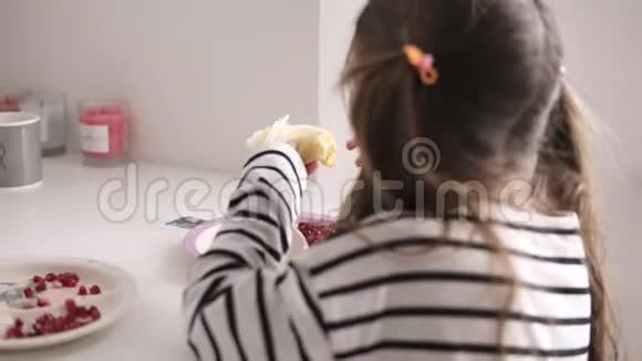 一个小女孩坐在椅子上吃着条纹衬衫做的薄煎饼视频的预览图