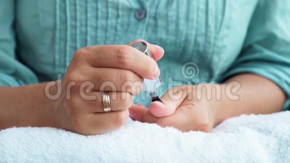 在家修指甲时女人在指甲上涂指甲油女人把指甲擦得紧紧的家庭修指甲及视频的预览图
