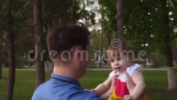 爸爸抱着孩子笑着和他在城里散步视频的预览图