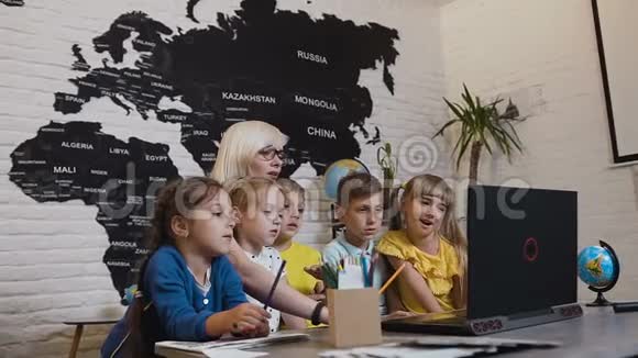 年轻的女老师和一群学生讨论电脑程序使用笔记本电脑的女教师视频的预览图