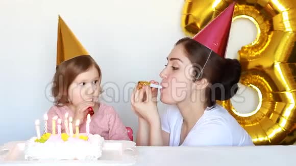 生日快乐的妈妈和孩子生日蛋糕母亲她的女儿在白色的背景下微笑和大笑3年视频的预览图