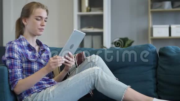 悲伤的女人在沙发上用平板电脑时对损失做出反应视频的预览图