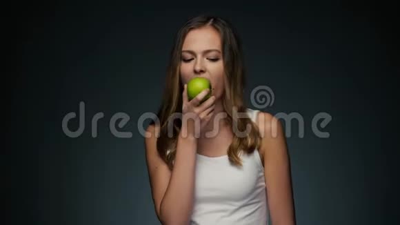 年轻美丽的高加索女人与苹果的肖像吃饭和微笑视频的预览图