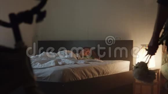 当男人带着鲜花进入房间时漂亮的女孩睡在卧室里视频的预览图