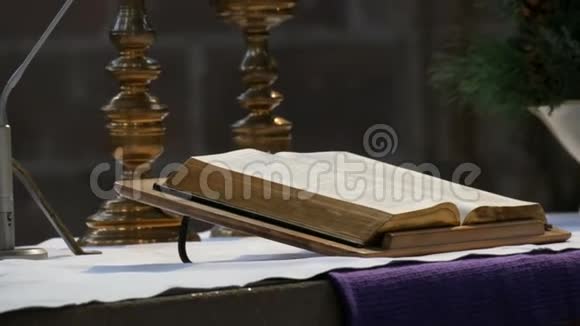 这本伟大的牧师的书躺在古老的天主教会的祭坛上视频的预览图
