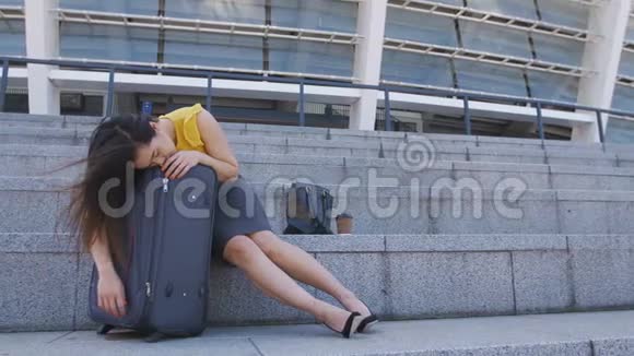 亚洲商界女性睡在户外的手提箱里视频的预览图
