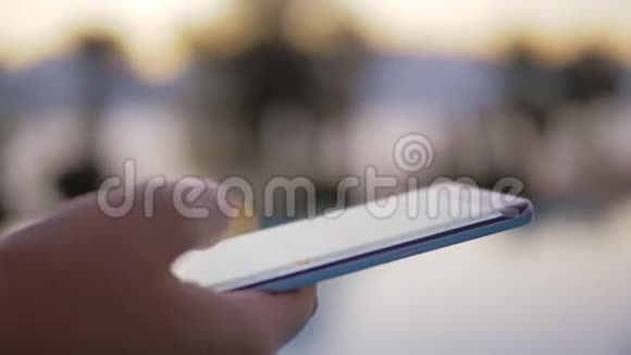 手中的智能手机和模糊的南方风景视频的预览图