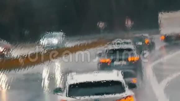 雨中公路交通堵塞的景象汽车连续行驶雨点般的落在窗户上一道道道痕视频的预览图