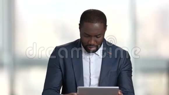 穿西装的黑人在平板电脑上玩游戏视频的预览图