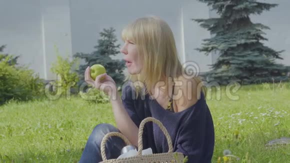女人在公园放松吃苹果视频的预览图