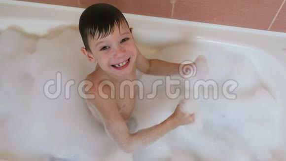 男孩67岁坐在浴缸里泡沫看着相机微笑着上景视频的预览图