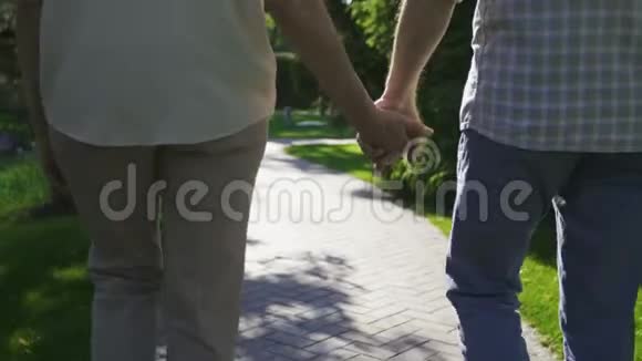 一对亲密的老夫妇在散步时牵手视频的预览图
