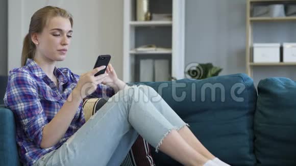 兴奋的休闲女性使用智能手机视频的预览图