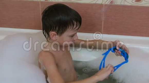 男孩67岁坐在泡泡浴和戴上护目镜视频的预览图
