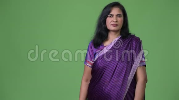 成熟美丽的印度女人穿着萨里传统的衣服向背后展示一些东西视频的预览图