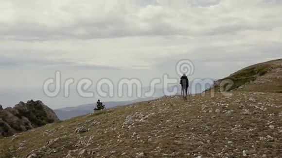 带背包的人正在山上徒步旅行背景上美丽的云朵体育健身和健康生活方式视频的预览图