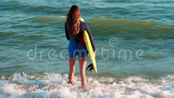 慢动作苗条的女孩专业冲浪者沿着海滩来到大海穿着黄色冲浪板的手里视频的预览图