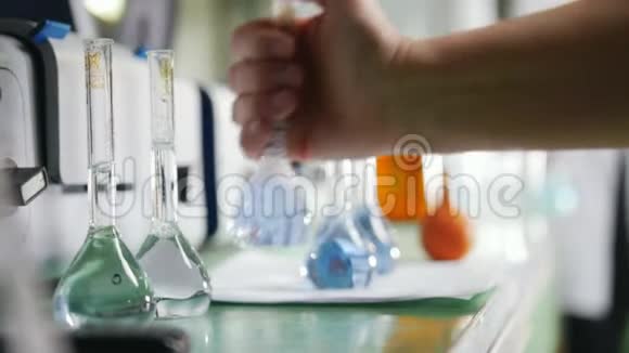 装满不同液体的化学品和烧瓶的桌子视频的预览图