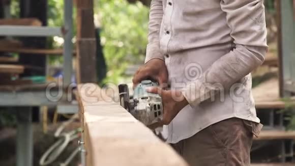 工匠在木工工作时使用轨道砂眼工人用砂光机打磨木板维修工视频的预览图