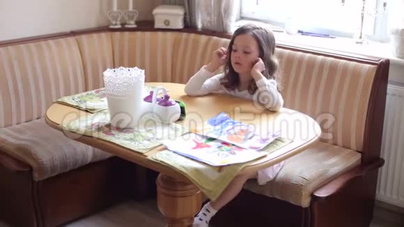 餐桌上一个悲伤的小女孩的肖像视频的预览图