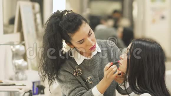 化妆师用口红画女人嘴唇视频的预览图