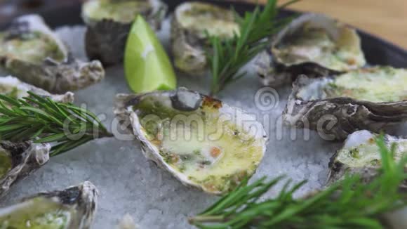 用奶酪草药和石灰烤的牡蛎放在盘子里海鲜背景地中海美食和海鲜视频的预览图