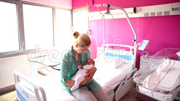 一位母亲在医院里看着她刚出生的婴儿视频的预览图