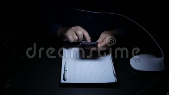 商人在黑暗办公室文本写作在线消息使用智能手机视频的预览图