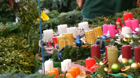 许多不同的五彩蜡烛作为圣诞节和新年的装饰被冬青的树枝包围着视频的预览图