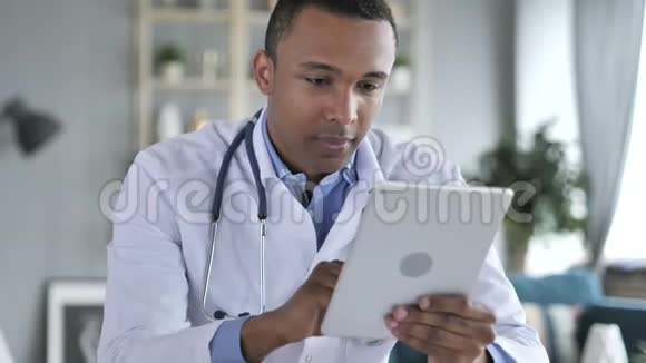 非裔美国医生使用平板电脑浏览互联网视频的预览图