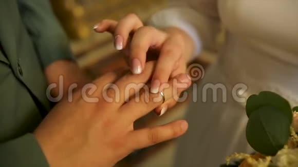 把结婚戒指戴在新郎身上爱情和婚姻结婚典礼把新郎的金戒指视频的预览图