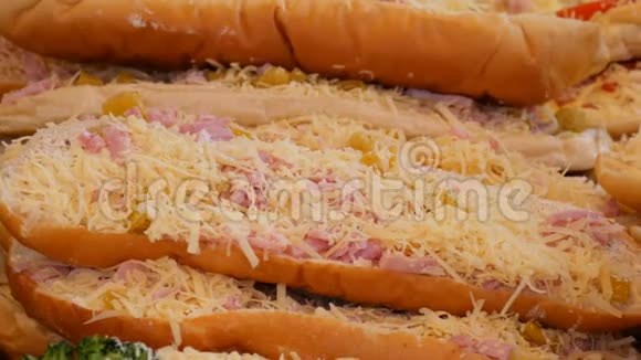 上面有一大块面包是香肠磨碎的奶酪和腌制的黄瓜在柜台上的大三明治视频的预览图