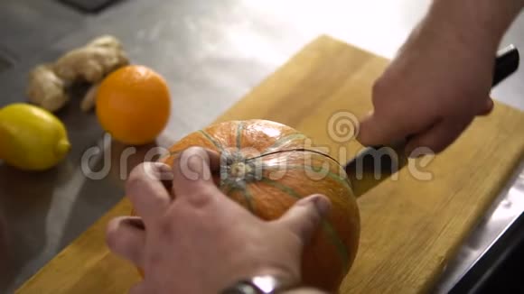 厨师在厨房把大南瓜切成两半视频的预览图