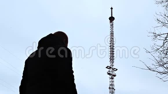一个拿着电话的人正站在电话塔旁拨通电话号码试图接通网络这是个坏消息视频的预览图